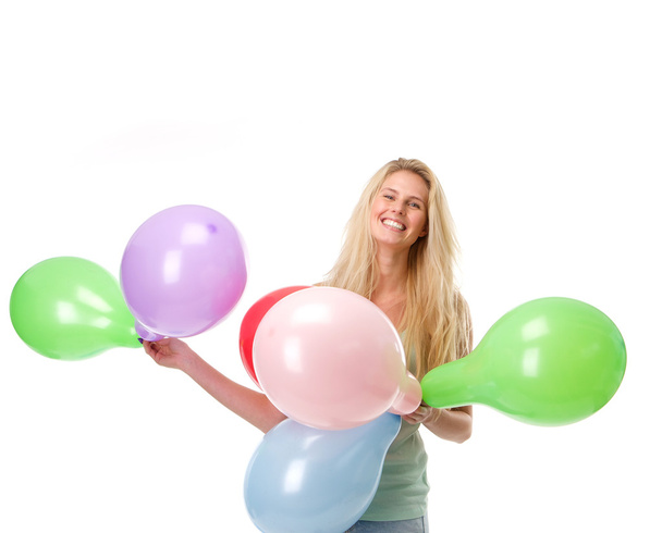 χαμογελώντας νέα γυναίκα που κρατά μπαλόνια  - 写真・画像