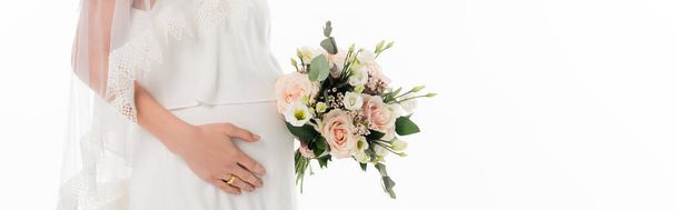 白いバナーに隔離された結婚式の花束を保持している妊婦の花嫁のクロップドビュー - 写真・画像