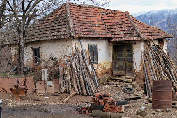 Muy antigua casa de campo arruinada y abandonada en Serbia. Casa blanca con techo rojo y en la montaña - Foto, imagen