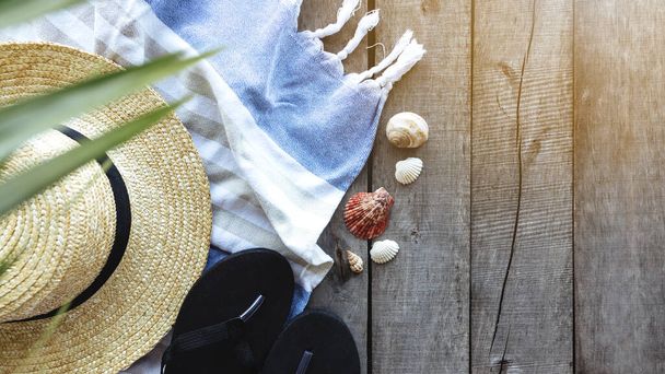 Travel, vacation, weekends concept. Straw hat, palm leaf, shoes, towel, shells - Photo, Image