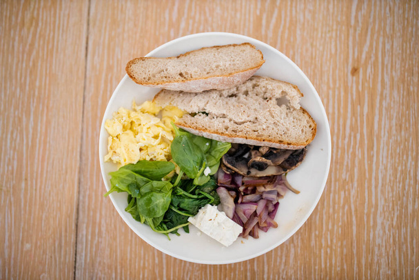 Ovos mexidos e prato de espinafre com fatias de pão e queijo - Foto, Imagem