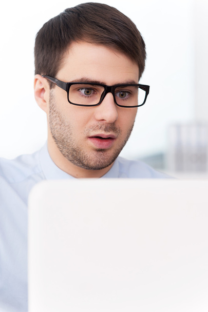 Surprised man looking at laptop - Photo, Image