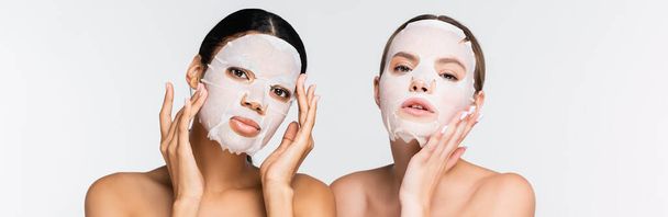 young multiethnic women in moisturizing sheet masks isolated on white, banner - Photo, Image