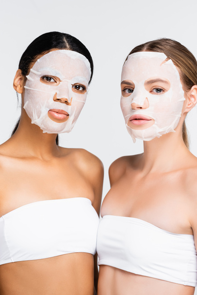 mulheres jovens inter-raciais em máscaras de folhas hidratantes isoladas em branco  - Foto, Imagem