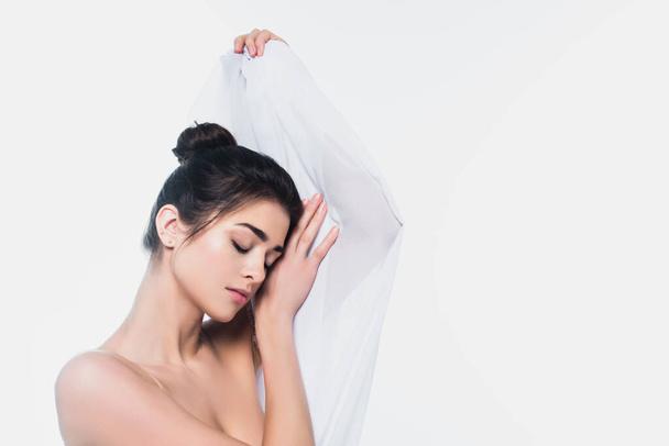 Mladá žena s nahými rameny drží látku izolovanou na bílém  - Fotografie, Obrázek