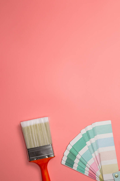 Paintbrush with palette for painting sample with pastel colors on pink background top view, Flat lay,copy space, home,construction,decoration,business concept background - 写真・画像