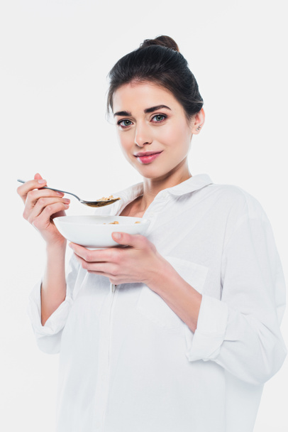 Όμορφη γυναίκα κρατώντας μπολ με δημητριακά και κουτάλι απομονώνονται σε λευκό  - Φωτογραφία, εικόνα
