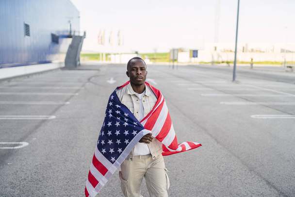 A closeup shot of a black male holding the flag of the USA - Fotografie, Obrázek