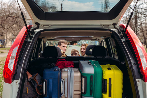 giovane famiglia pronta per il viaggio in auto. bagagliaio pieno di bagagli. concetto di viaggio su strada - Foto, immagini