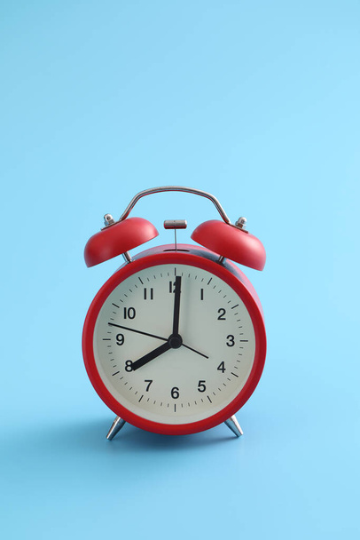 Red retro alarm clock isolated on a blue backgroun - Photo, Image