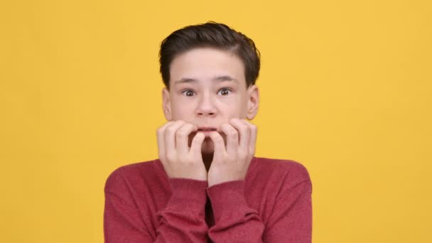assustado teen menino sacudindo a partir de medo posando sobre amarelo fundo - Filmagem, Vídeo
