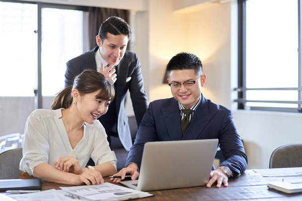 Les gens d'affaires asiatiques et latins ayant des conférences web sur un ordinateur - Photo, image
