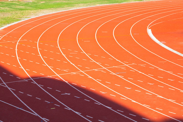 Running track is a rubberized artificial running surface for track in stadium.  - Photo, Image