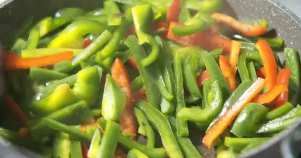 smažení zelené a červené papriky na pánvi - Záběry, video
