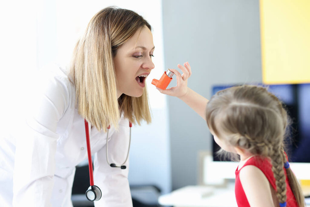 Маленька дівчинка розпилює гормональний інгалятор лікаря в клініці
 - Фото, зображення