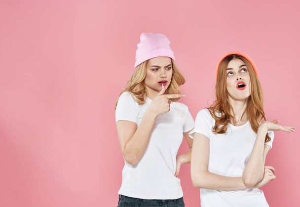 funny women in t-shirts glamorous hats cropped view pink background - Zdjęcie, obraz