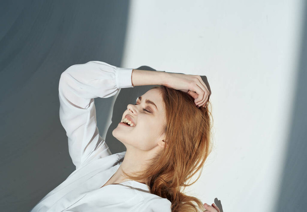 Woman on a light background in white clothes makeup red hair model - Φωτογραφία, εικόνα