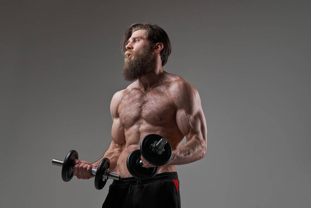 Healthy lifestyle of a sportsman with bearded face and dumbells - Photo, Image