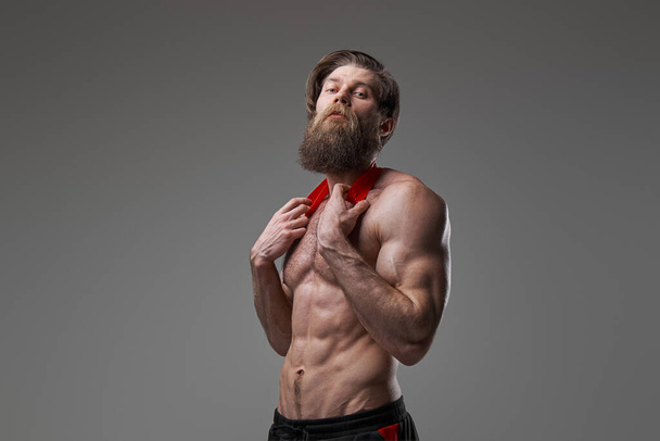 bodybuilder cool et élégant pose avec des bandes de résistance en studio - Photo, image
