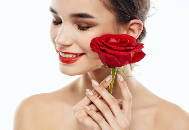 Mulher com olhos fechados Maquiagem no rosto e flor vermelha ombros nus - Foto, Imagem