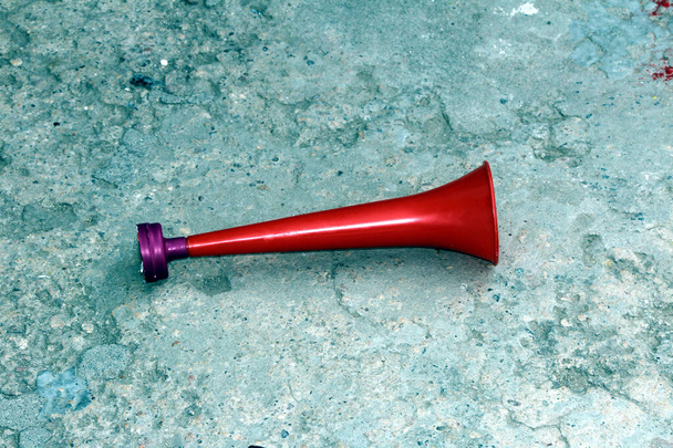 Cuerno de plástico del estadio Vuvuzela en blanco, trompeta vuvuzela ventilador aislado sobre fondo de piedra - Foto, imagen