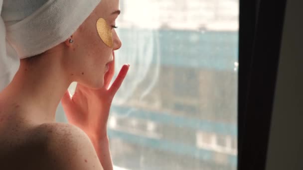 femme caucasienne aux épaules nues applique des patchs hydrogel sous les yeux - Séquence, vidéo