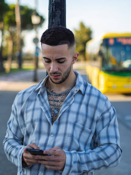 A Spanish stylish man with tattoos talking on phone - Fotó, kép