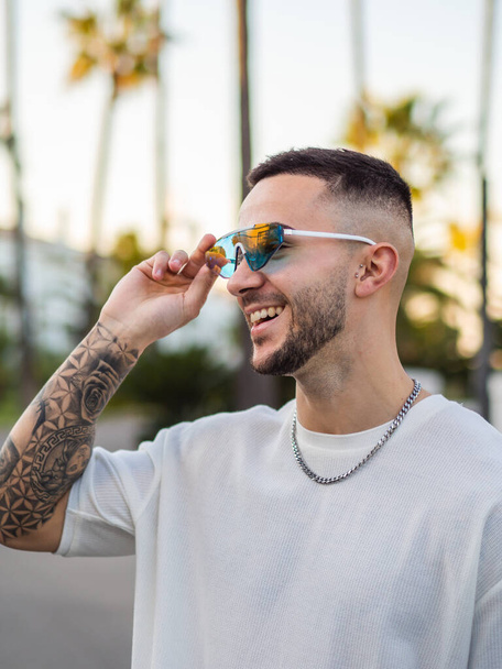 Een Spaanse coole man met tatoeages en zonnebril - Foto, afbeelding