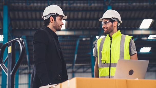 Két gyári munkás dolgozik és tárgyalnak a gyárban a gyártási tervről . - Fotó, kép