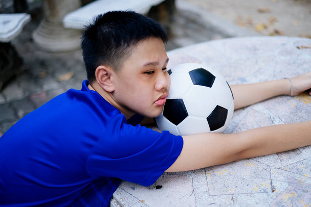 A little boy is exhausted after his football training. - Photo, Image