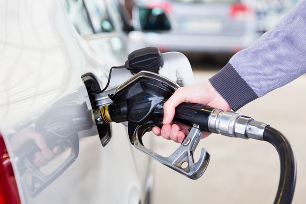 benzine gepompt in een motorvoertuig auto. - Foto, afbeelding