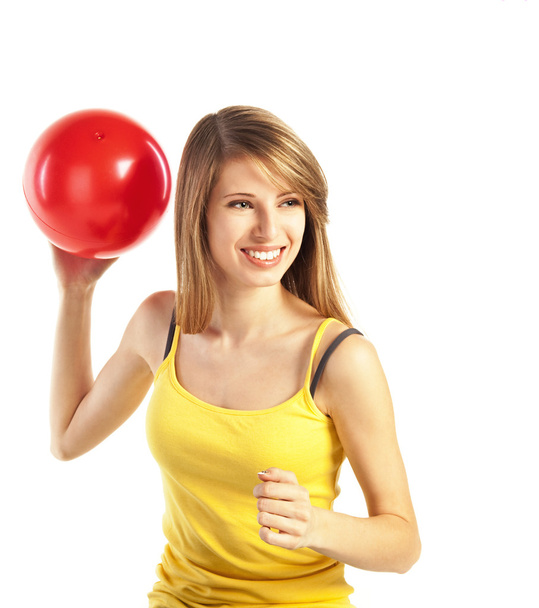 hübsch lächelnde junge blonde Frau in sportlichen Tüchern mit rotem Ball - Foto, Bild