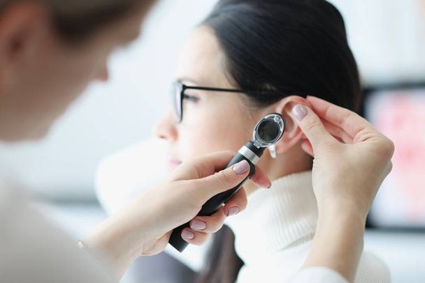 Otorhinolaryngologue examine l'oreille du patient avec un otoscope - Photo, image