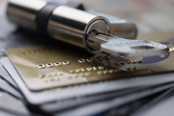Cerradura con llave descansa en tarjetas de crédito de plástico - Foto, imagen