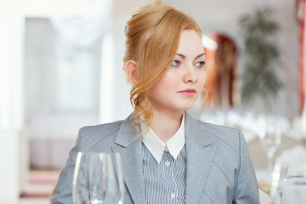 Confident young girl posing at table in restaurant - Foto, afbeelding