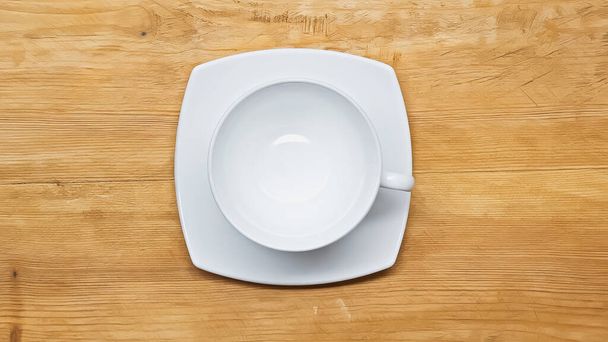 vista dall'alto di bianco, tazza vuota e piattino sulla superficie di legno - Foto, immagini