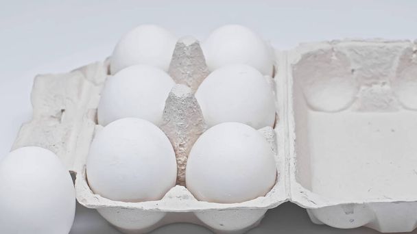 paquet de carton avec des œufs de poulet sur la surface blanche - Photo, image