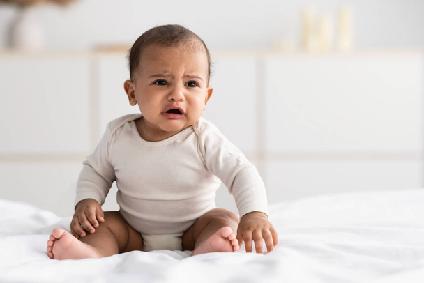 Porträt eines traurigen schwarzen Babys, das allein weint - Foto, Bild