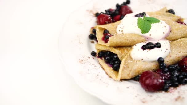 pancake con cioccolato e bacche su un piatto bianco.4K video - Filmati, video