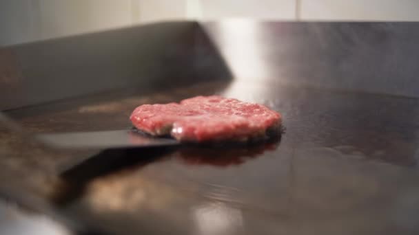 Ein Rind- und Schweineschnitzel für einen Burger kochen. In der Küche gebratenes Fleisch. der Koch wendet das Fleisch mit dem Spachtel. - Filmmaterial, Video