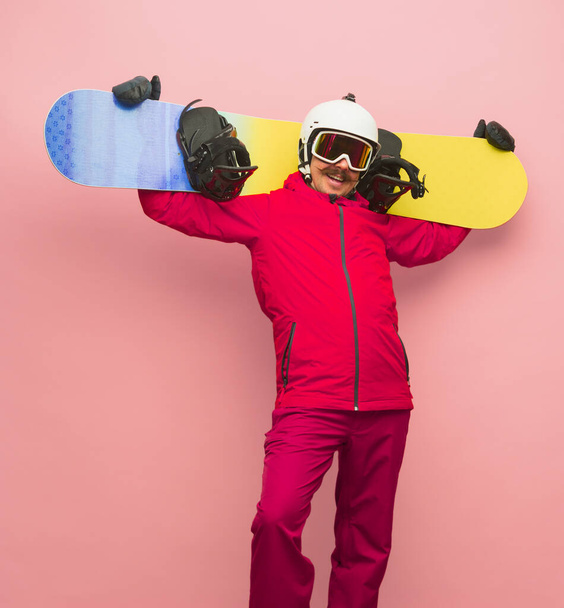 Male snowboarder with skiing gear in bright ski suit isolated on pink background - Photo, Image