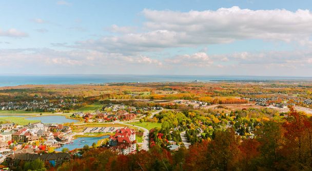 Magnificent beautiful aerial view from the mountain on Blue Mountain village area with Georgian Bay, Lake Huron in background on sunny day, autumn season - Photo, Image