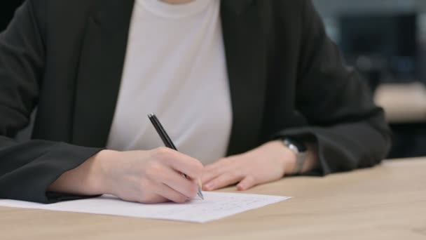 Κοντινό πλάνο των γυναικείων χεριών γράφοντας σε χαρτί - Πλάνα, βίντεο