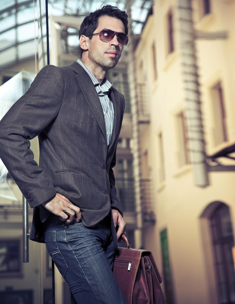 Confident young businessman holding a briefcase - Foto, Imagen