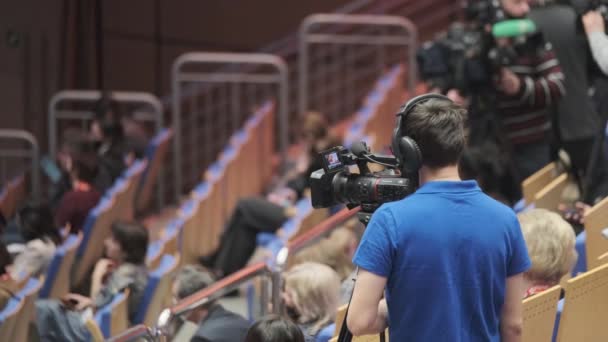 Videographer in protective mask working in auditorium - Footage, Video