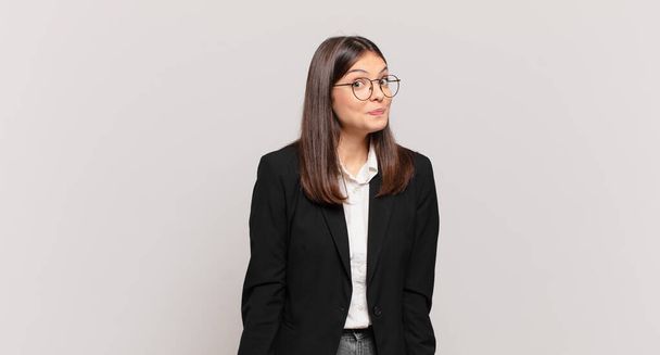 young business woman with a goofy, crazy, surprised expression, puffing cheeks, feeling stuffed, fat and full of food - 写真・画像