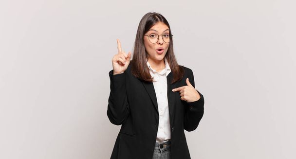 young business woman feeling proud and surprised, pointing to self confidently, feeling like successful number one - Photo, image