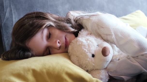 Meisje slaapt met teddybeer in slaapkamer thuis. - Video