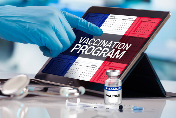 Επαγγελματίας που εργάζεται στο ημερολόγιο του σχεδίου εμβολίων για το έθνος της Γαλλίας, έννοια της ανοσοποίησης. Εργασία με δισκίο στο πρόγραμμα του προγράμματος εμβολιασμού για τη Γαλλία. Photomontage με τρισδιάστατη απεικόνιση - Φωτογραφία, εικόνα