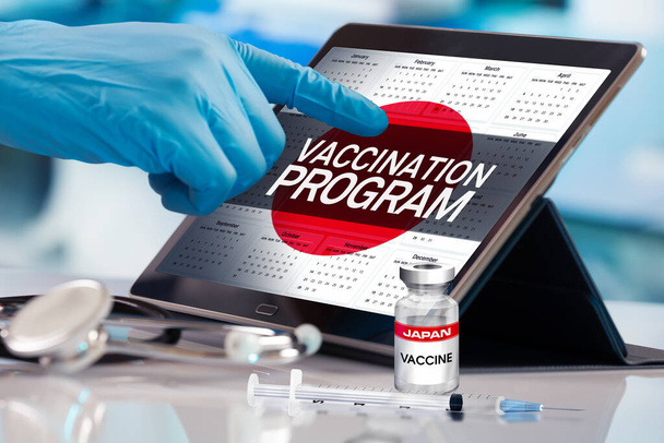 Επαγγελματίας που εργάζεται στο ημερολόγιο του σχεδίου εμβολίων για το έθνος της Ιαπωνίας, έννοια της ανοσοποίησης. Εργασία με δισκίο στο πρόγραμμα του προγράμματος εμβολιασμού για τον Καναδά. Photomontage με τρισδιάστατη απεικόνιση - Φωτογραφία, εικόνα